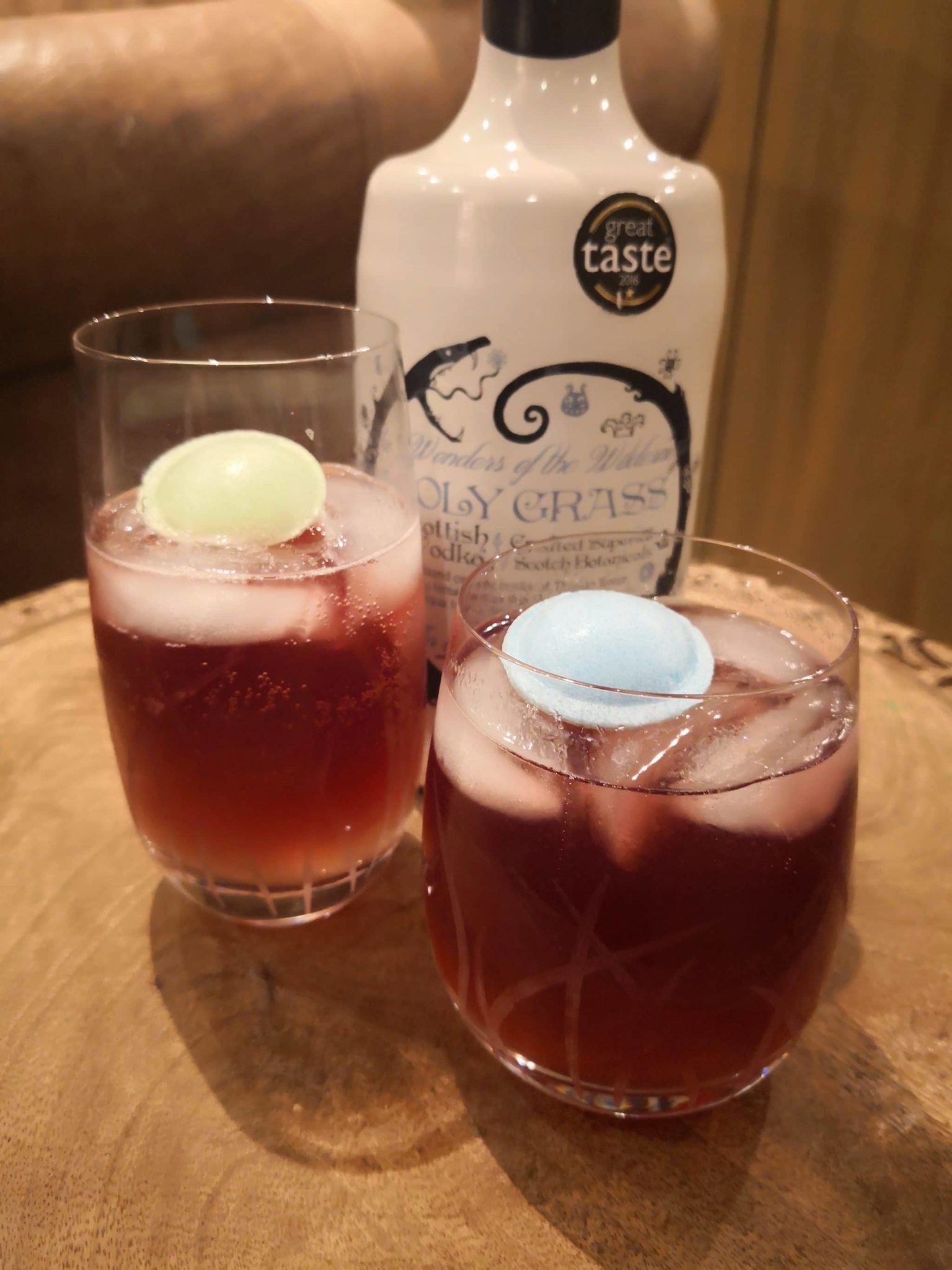 Bottle of Holy Grass Vodka and Dunnet Bay Cooler cocktail served in two glassed with ice and garnished with a flying saucer