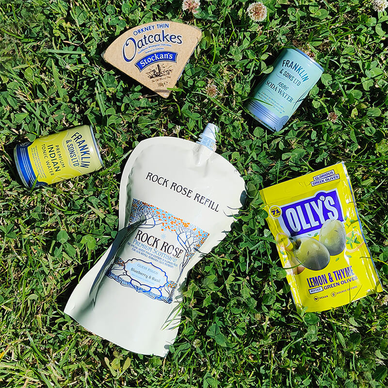 Content of the Refill Reward Club box for July 2023 including Rock Rose Gin Blueberry & Basil Guest pouch, Tonic water, Indian tonic water, green olives and oatcakes
